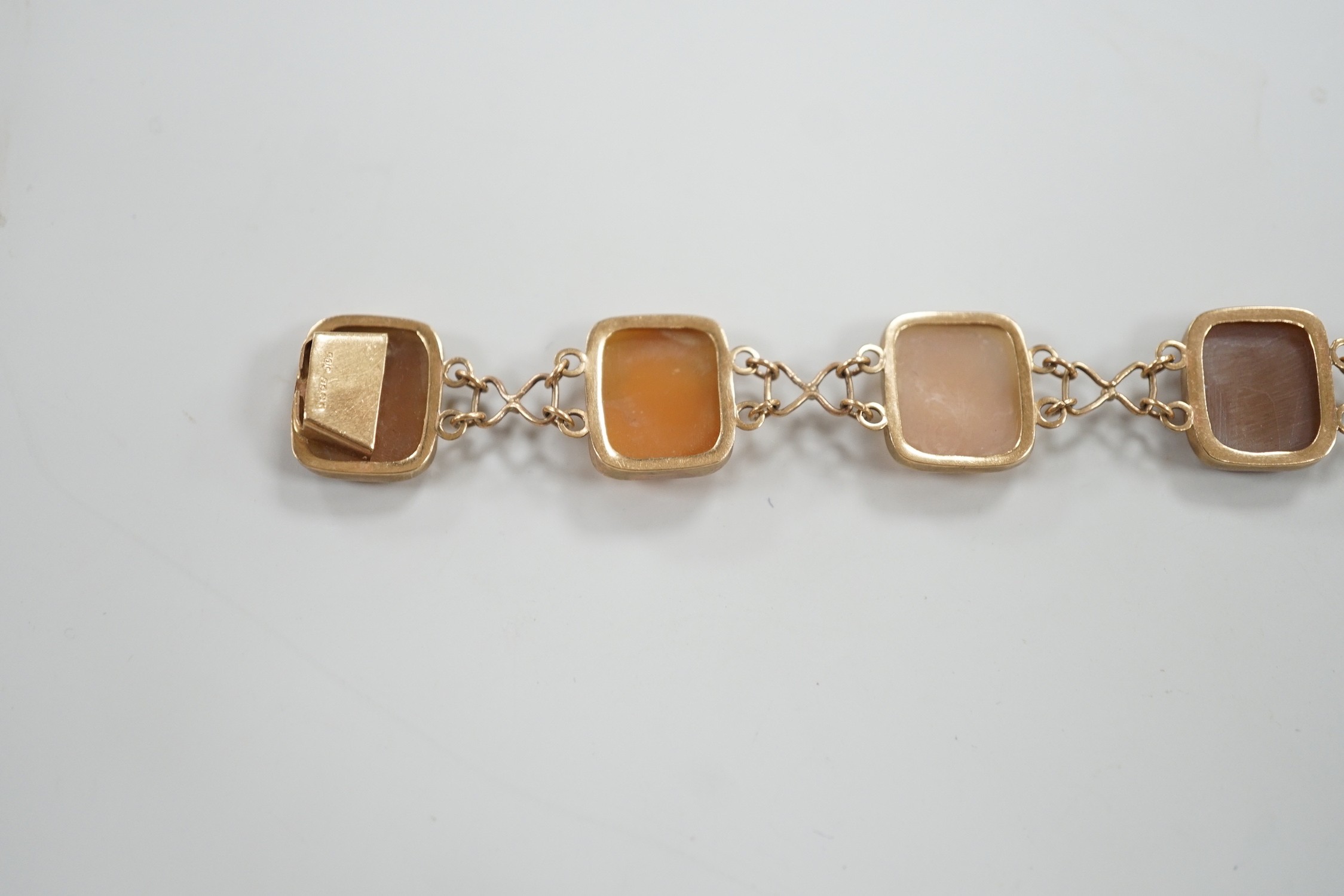 A 1970's 9ct gold and seven cameo panel set bracelet, carved with busts of ladies or flowers, 18cm, gross weight 10.3 grams.